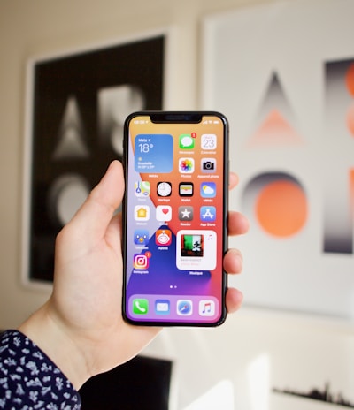 Close-up of hands holding a smartphone showing the jueganexo app interface with colorful game icons.